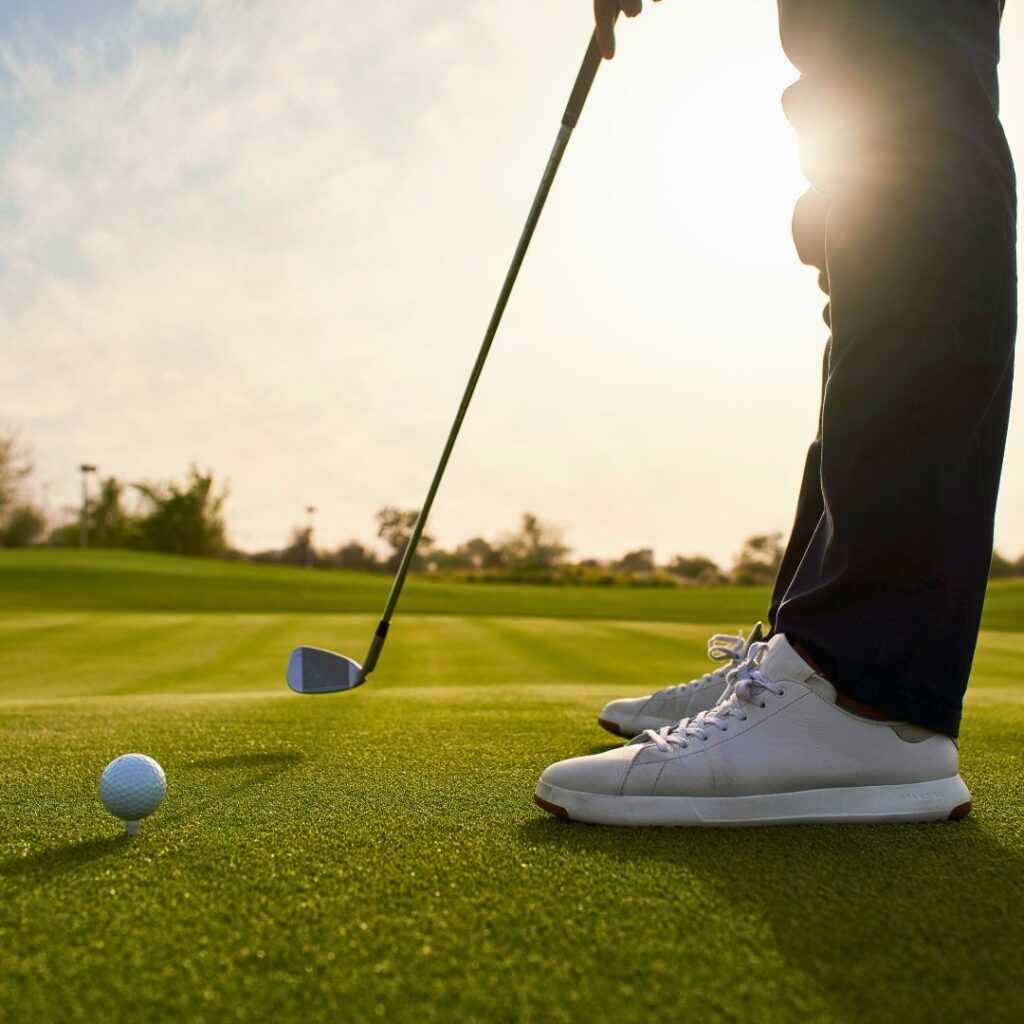 Golfer preparing to putt on a sunlit golf course during a luxury golf holiday.