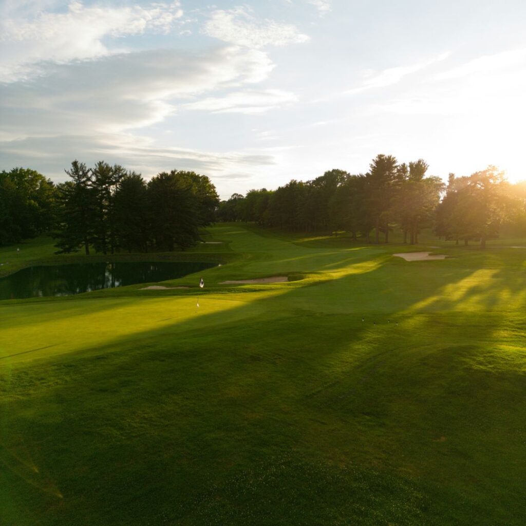 Scenic golf course with tree-lined fairways and sunset views.