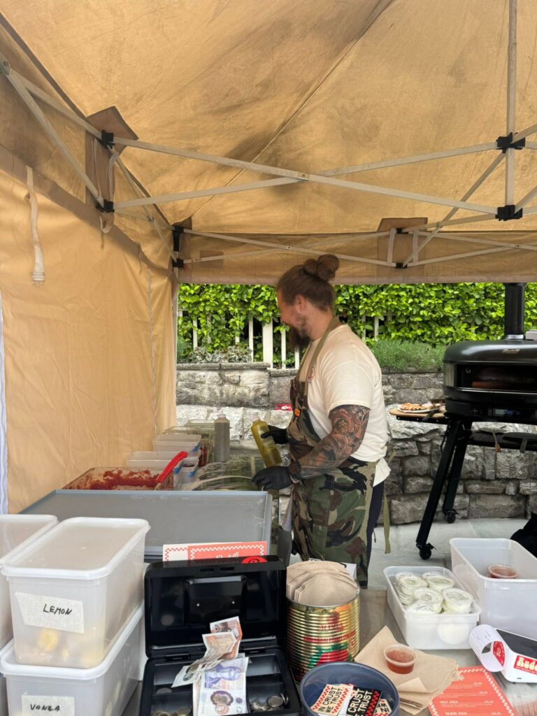 Independent food vendor serving customers from an outdoor stall