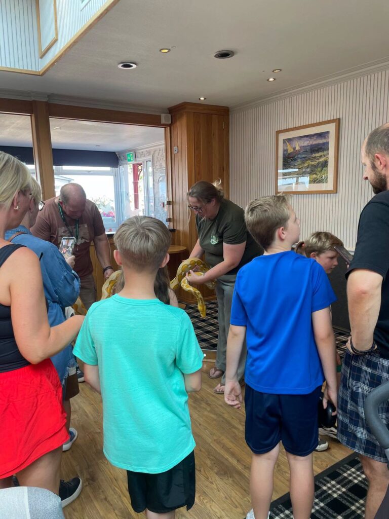 Children and families meeting a snake at The Beach Fun Day